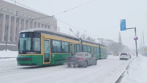 The heavy snowfall in Helsinki. Snow-covered city. Trams are moving through the Stock Footage 186972605