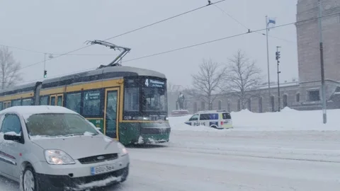 The heavy snowfall in Helsinki. Snow-covered city. Trams are moving through the Stock Footage 186979097
