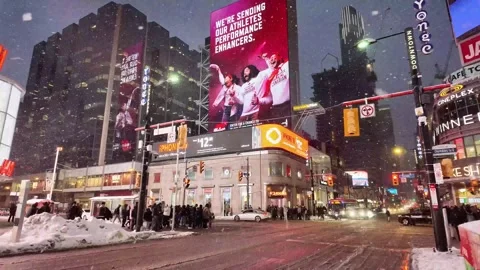 Heavy snowfall over Yonge-Dundas Square in downtown Toronto at night Stock Footage 327992743