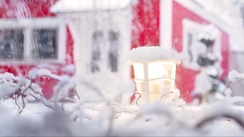 Heavy snowfall with red house defocused in the background Stock Footage 98484299
