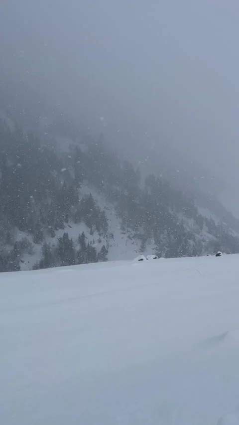 Heavy snowfall static shot of remote forzen valley Video stock 327690330