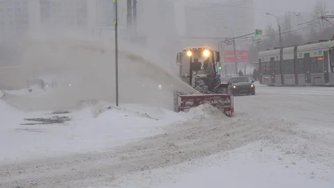 Heavy snowfall. Tractor cleaning snow snowthrower. Removing snow with plow. Stock Footage 103135841