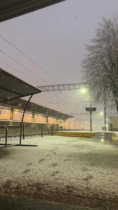 Heavy snowstorm at train station with lone person walking away Stock Footage 310138731