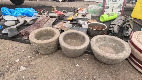 Heavy Stone Mortars and Rusty Metal Scrap Displayed Outdoors at Flea Market Sale Stock Footage 346083656