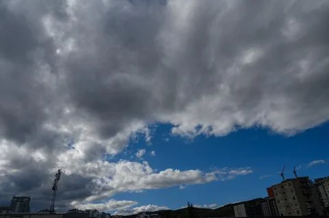 Heavy storm clouds and blue sky over city horizon in Tbilisi, Georgia Stock Photos