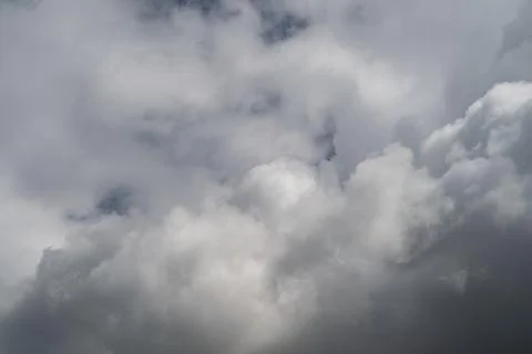 Heavy storm clouds overcast sky, textured masses roll in deep gray tones, bro 스톡 사진
