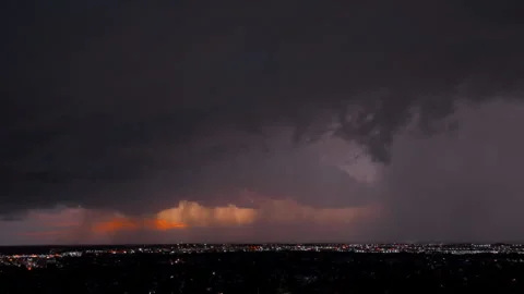 Heavy stormy clouds illuminated by lightning over a colorful sunset sky. Stock Footage 297096152
