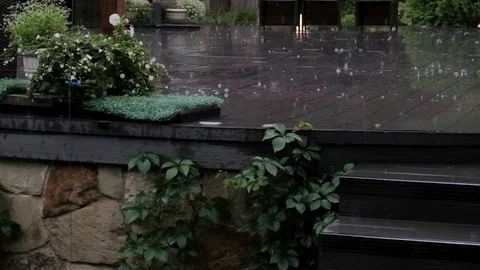 Heavy summer rain drumming on the dark wooden floor, creating water bubbles Stock Footage 129086157