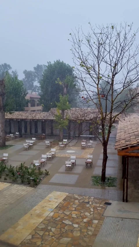 Heavy summer rain storm downpour over a traditional Mediterranean resort hotel Stock Footage 336278743