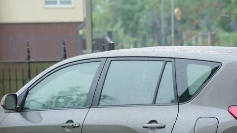 Heavy summer raindrops fall car roof surface. rainy weather rain drops knock Stock Footage 240347053