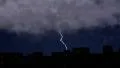 Heavy thunderstorm clouds above city rooftops, severe lightning storm with sound 4k or 4k+ Resolution