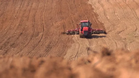 A heavy tracked tractor plows and buries a field in early spring, a plowed field Stock Footage 156076338