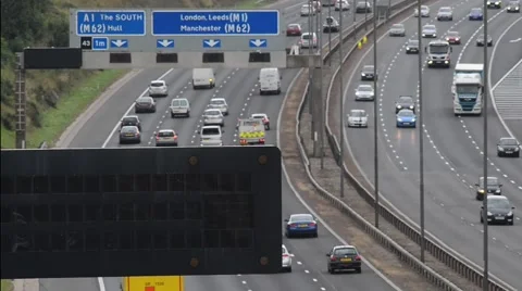 Heavy traffic on motorway at rushour reflected in gantry warning sign, Leeds, uk Stock Footage 66298150