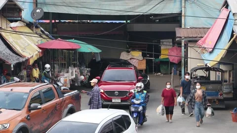 Heavy traffic at a small intersection next to the market at dusk Stock Footage 220563859
