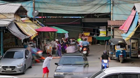 Heavy traffic at a small intersection next to the market at dusk, time lapse Stock Footage 220565053