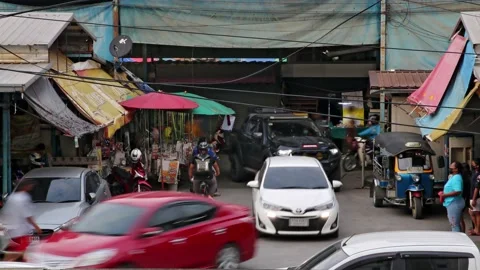 Heavy traffic at a small intersection next to the market at dusk, time lapse Stock Footage 220823682
