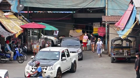 Heavy traffic at a small intersection next to the market at dusk Stock Footage 223371251