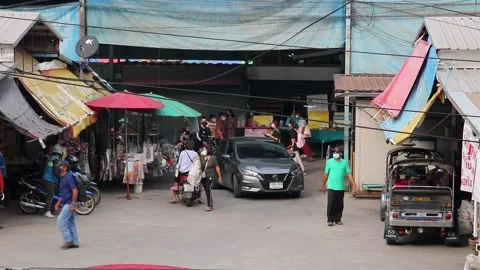 Heavy traffic at a small intersection next to the market at dusk Stock Footage 227888345