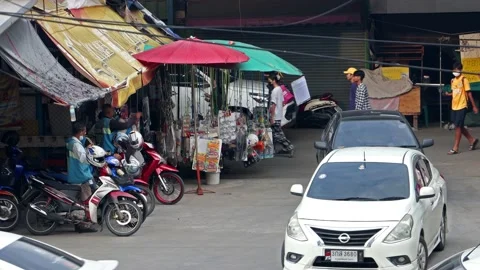 Heavy traffic at a small intersection next to the market at dusk Stock Footage 227889593