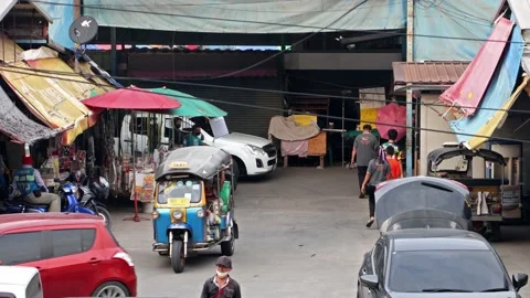 Heavy traffic at a small intersection next to the market at dusk Stock Footage 233231778