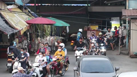 Heavy traffic at a small intersection next to the market at dusk Stock Footage 235422004