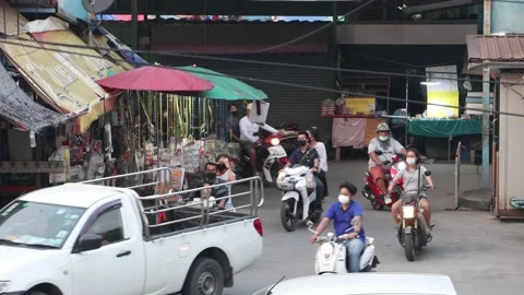Heavy traffic at a small intersection next to the market at dusk Stock Footage 237819471