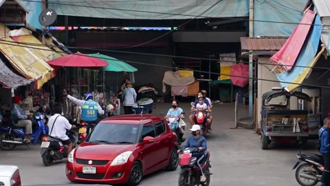 Heavy traffic at a small intersection next to the market at dusk Stock Footage 243364355