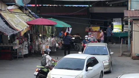 Heavy traffic at a small intersection next to the market at dusk Stock Footage 265825452