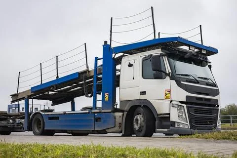 A heavy truck stands at a loading area. Ramps are visible on top, ready for l Stock Photos