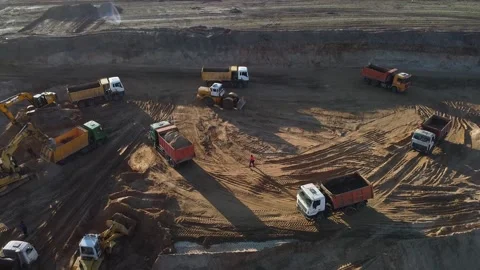 Heavy vehicles excavating and transporting sand on sandpit or quarry Stock Footage 158040378