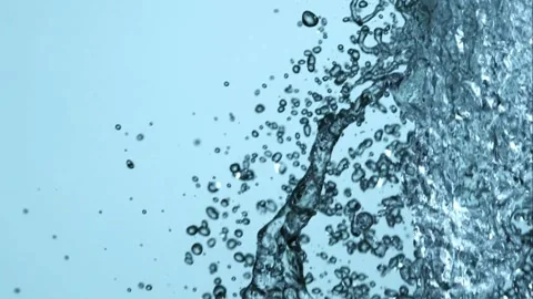 A heavy wall of water splashes and falls on a blue background Video stock 326625405