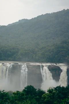 Heavy waterfall besides the forest Stock Photos