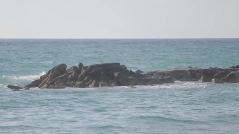 Heavy wave breaking in slow motion. Sea Ocean wave splashes across a rock Video stock 155920078