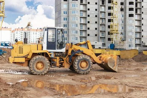 Heavy wheel loader with a bucket at a construction site. Stock Photos