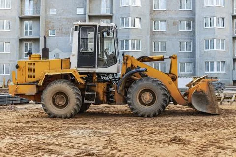 Heavy wheel loader with a bucket at a construction site. Photos