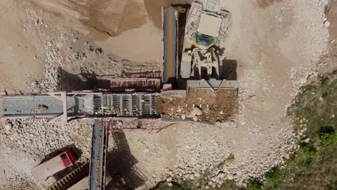 A heavy wheel loader dumping aggregates in a screening machine in a quarry Stock Footage 196890456