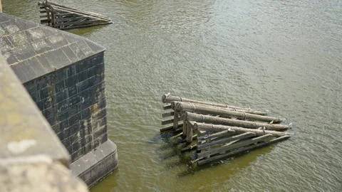 Heavy wooden icebreakers protect a stone pier of Charles Bridge in Prague. Stockbeeldmateriaal 341971329
