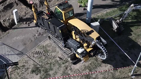 Heavy yellow drilling machine with crawler tracks and hydraulic hoses working at Stock Footage 315159498