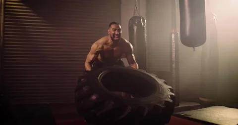 A Heavyweight Hispanic Bodybuilder Tyre Flipping In A Crossfit Gym Stock Footage 158441228