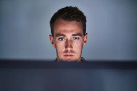 Hed be lost without his computer. a focussed young programmer working at his Stock-Fotos