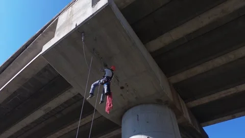 Height worker hanging from bridge during inspection Stock Footage 306758308