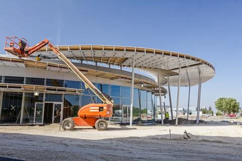 Height workers with help of cherry picker are working on new metal canopies Stock Photos