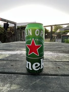 Heineken beer can resting on a rustic wooden picnic table at the Rotorua Ce.. Stock Photos