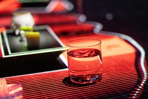 Held glass on reflective surface, in red Stock Photos
