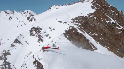 Heli-Skiing helicopter unloading gear on a snowy mountain in Alaska Video stock 230334076
