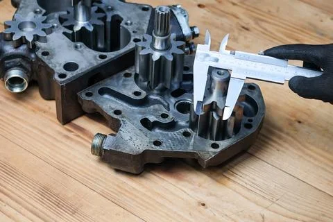 Helical gear pump component measurement with vernier caliper. Stock Photos