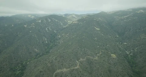 Helicopter aerial moving through clouds over green mountain landscapes, day Stock Footage 115053427