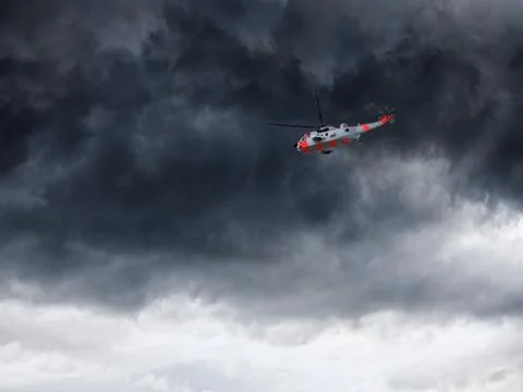 Helicopter and dark clouds Stock Photos