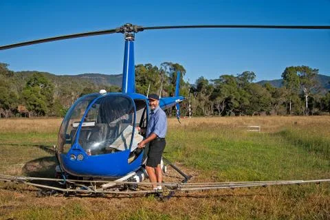 Helicopter and pilot with map get ready to fly. Agricultural work Stock Photos