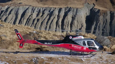 Helicopter arrival at Annapurna Base Camp during a serene morning, medium shot Stock Footage 303865151